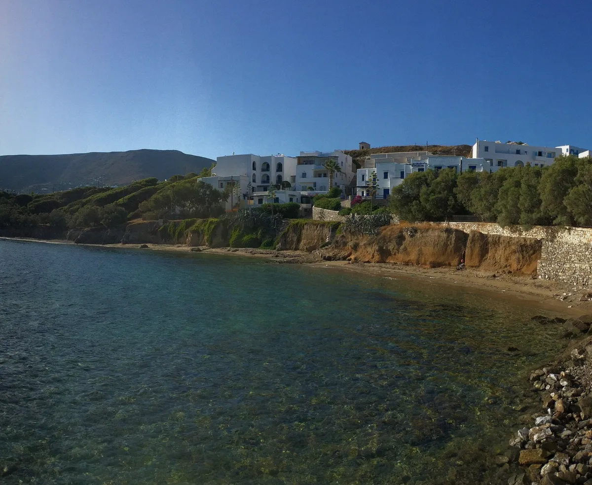 Wide beach with pale sand and clear water on Paros in season